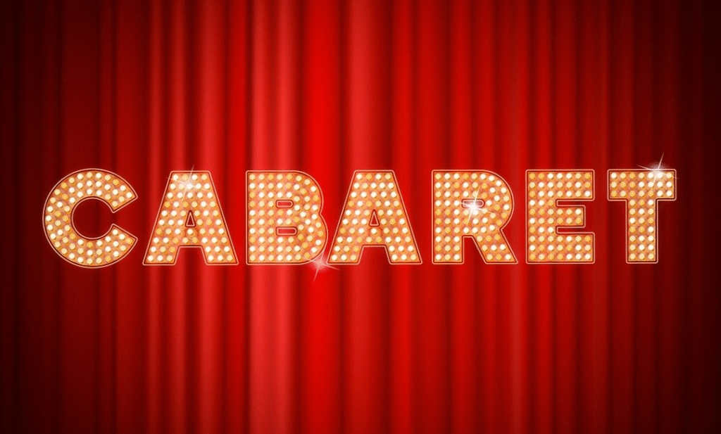 Cabaret Athens – Λαμπερή πινακίδα με φωτεινά γράμματα μπροστά από κόκκινη θεατρική κουρτίνα.