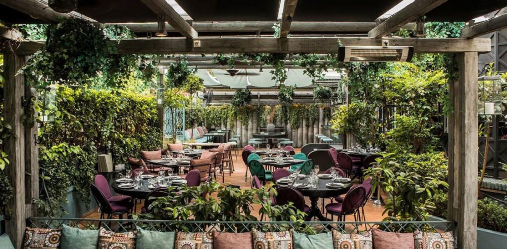 Ο καταπράσινος κήπος του The Albion στο Νέο Ψυχικό με elegant καθίσματα και χαλαρή ατμόσφαιρα.