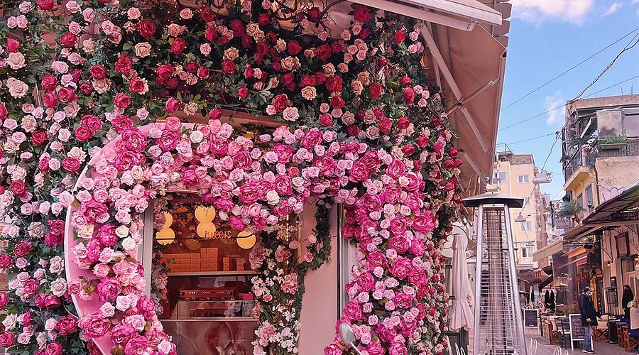 Η ροζ εξωτερική πρόσοψη του Ellyz Café στο Μοναστηράκι, διακοσμημένη με άνθη και γιορτινά στοιχεία.