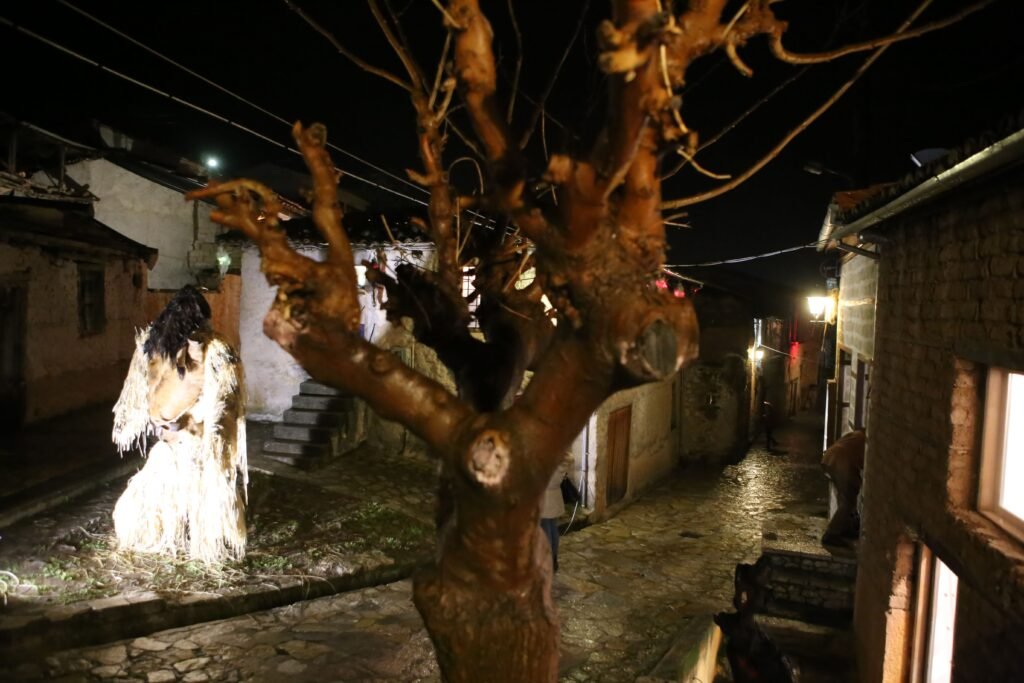 Η Νύχτα των Στοιχειών στην Άμφισσα δεν θυμίζει σε τίποτα τις συνηθισμένες αποκριάτικες γιορτές. Πρόκειται για ένα σκοτεινό λαϊκό δρώμενο, βασισμένο στον θρύλο του Στοιχειού της Χάρμαινας, που μετατρέπει την πόλη σε σκηνικό μύθου το τελευταίο Σαββατοκύριακο της Αποκριάς. Εδώ, οι Απόκριες δεν είναι θόρυβος και χρώμα, αλλά σιωπή, τελετουργία και συλλογική μνήμη. Ο θρύλος μιλά για τον Κωνσταντή, έναν νέο βυρσοδέψη της Χάρμαινας, του οποίου ο ανεκπλήρωτος έρωτας και ο τραγικός θάνατος τον καταδίκασαν να περιπλανιέται ως στοιχειό. Με τα χρόνια, η ιστορία αυτή δεν ξεχάστηκε. Αντίθετα, πέρασε από γενιά σε γενιά και κατέληξε να γίνει δρώμενο, όχι για να τρομάξει, αλλά για να θυμίσει πώς ο φόβος μπορεί να μετατραπεί σε τελετουργία. Κατά τη διάρκεια της Νύχτας των Στοιχειών, το στοιχειό «κατεβαίνει» από τη συνοικία Χάρμαινα και ακολουθεί μια τελετουργική πορεία μέσα στην πόλη. Μεταμφιεσμένοι σε ξωτικά, νεράιδες και αλλόκοτα πλάσματα συνοδεύουν τη διαδρομή, δημιουργώντας μια ατμόσφαιρα που περισσότερο βιώνεται παρά παρακολουθείται. Δεν υπάρχουν θεατές και πρωταγωνιστές. Όλοι γίνονται μέρος του ίδιου μύθου. Το Στοιχειό της Χάρμαινας απευθύνεται σε όσους αναζητούν Απόκριες με νόημα. Σε ταξιδιώτες που θέλουν να ζήσουν κάτι αυθεντικό, μακριά από στημένα θεάματα. Αν βρεθείς στην Άμφισσα εκείνο το Σαββατοκύριακο, δεν θα πεις ότι «είδες» ένα έθιμο. Θα πεις ότι περπάτησες μέσα σε έναν ζωντανό θρύλο.